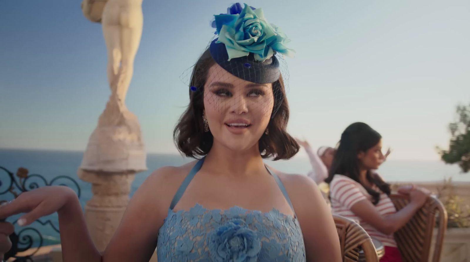 a woman wearing a blue dress and a flower in her hair