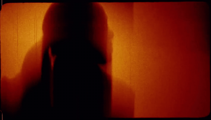 a blurry image of a person standing in front of a wall