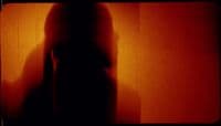a blurry image of a person standing in front of a wall