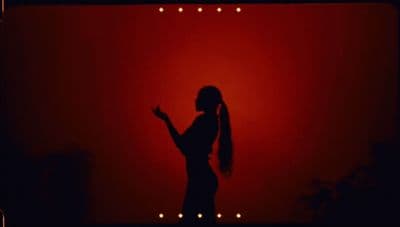 a woman standing in front of a red wall