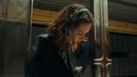 a woman sitting on a train looking at her cell phone