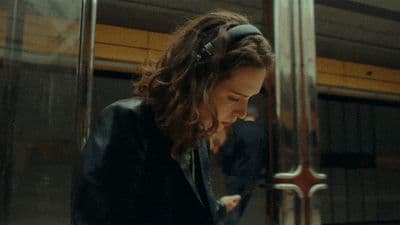 a woman sitting on a train looking at her cell phone