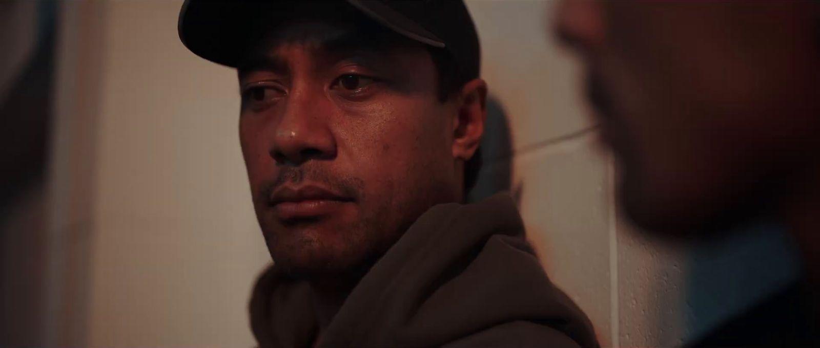 a man with a hat on looking at another man