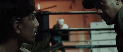 a man talking to another man in a boxing ring