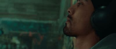 a man wearing headphones looking out a window