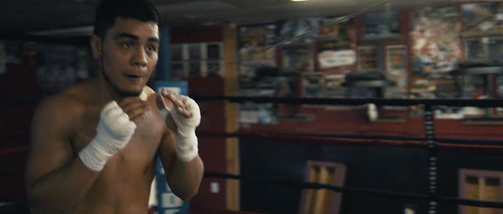 a young man wearing boxing gloves in a boxing ring