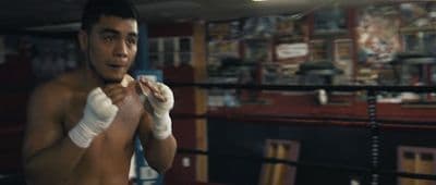 a young man wearing boxing gloves in a boxing ring