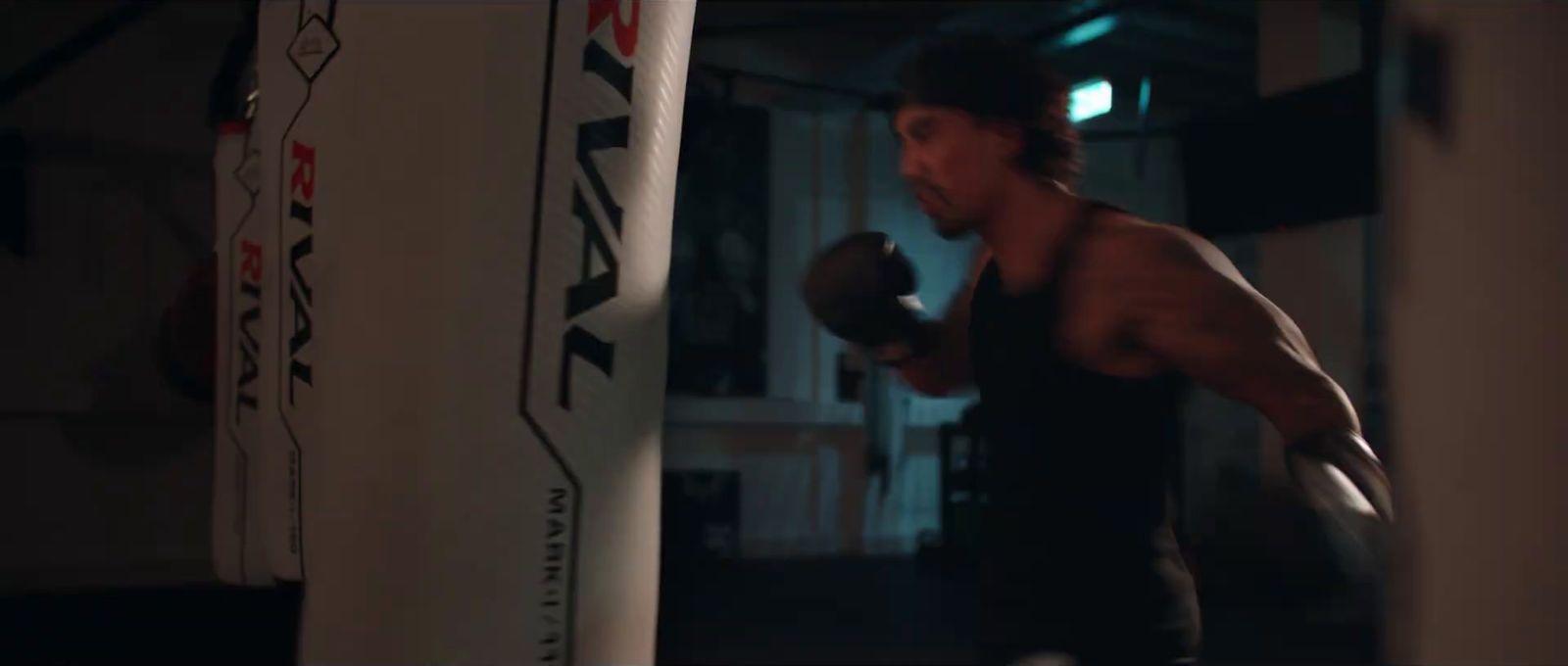 a man standing next to a punching bag