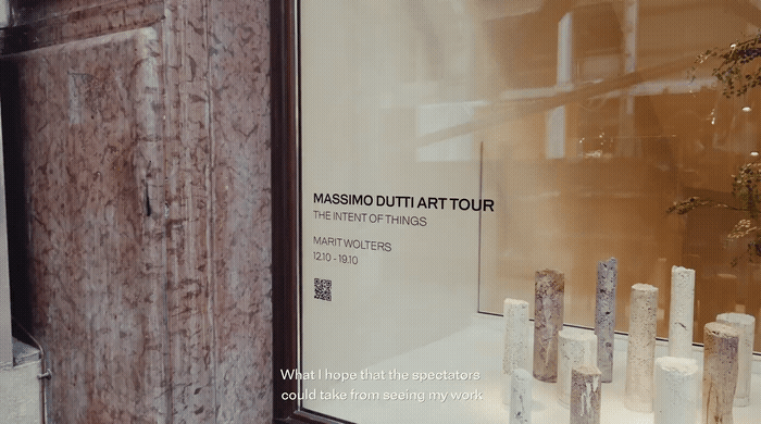 a window display of a museum with a vase of flowers