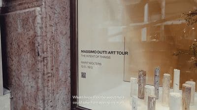 a window display of a museum with a vase of flowers