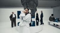 a group of people standing around a white room