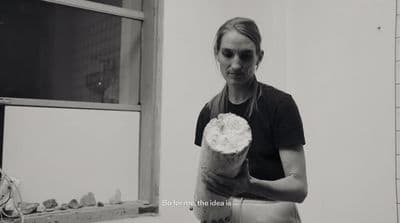 a black and white photo of a woman holding a pastry