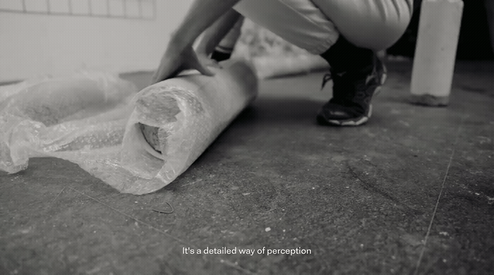 a black and white photo of a person wrapping a roll of toilet paper