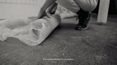 a black and white photo of a person wrapping a roll of toilet paper