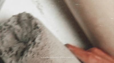 a hand is holding a mop in front of a wall