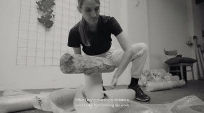 a woman is holding a large piece of wood