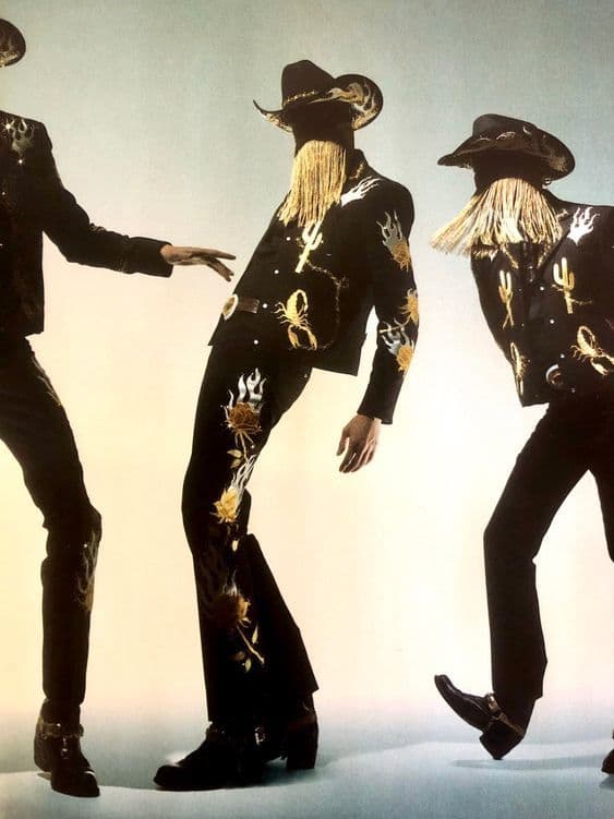 a group of three men dressed in black and gold
