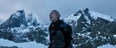 a man standing in front of snow covered mountains