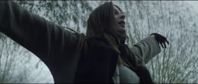 a woman with long hair holding her arms out