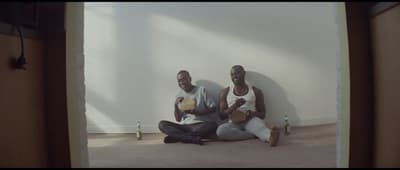 a couple of men sitting on the floor next to each other