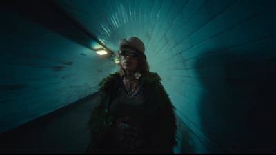 a woman standing in a tunnel with a hat on