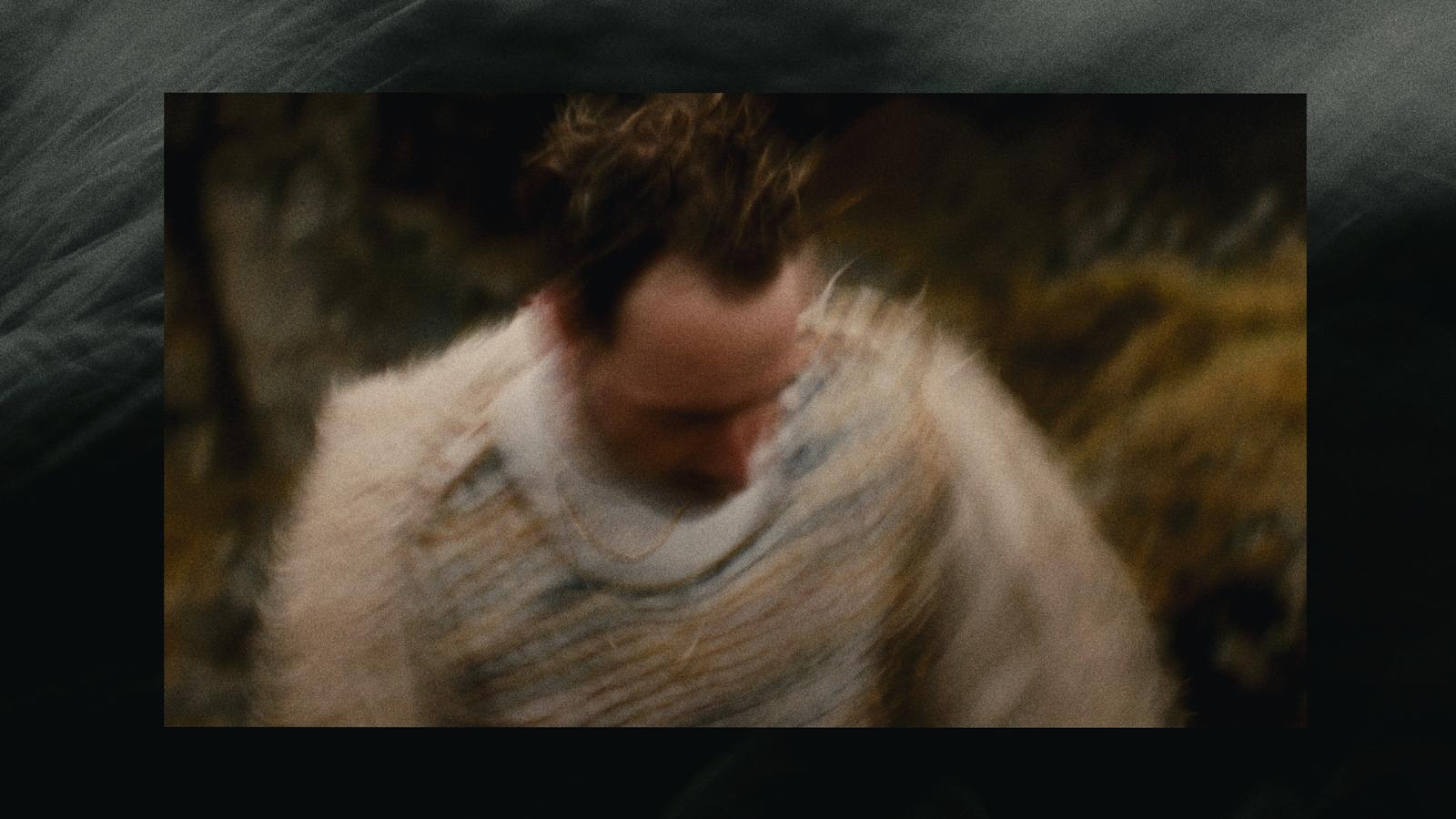 a blurry photo of a man wearing a sweater