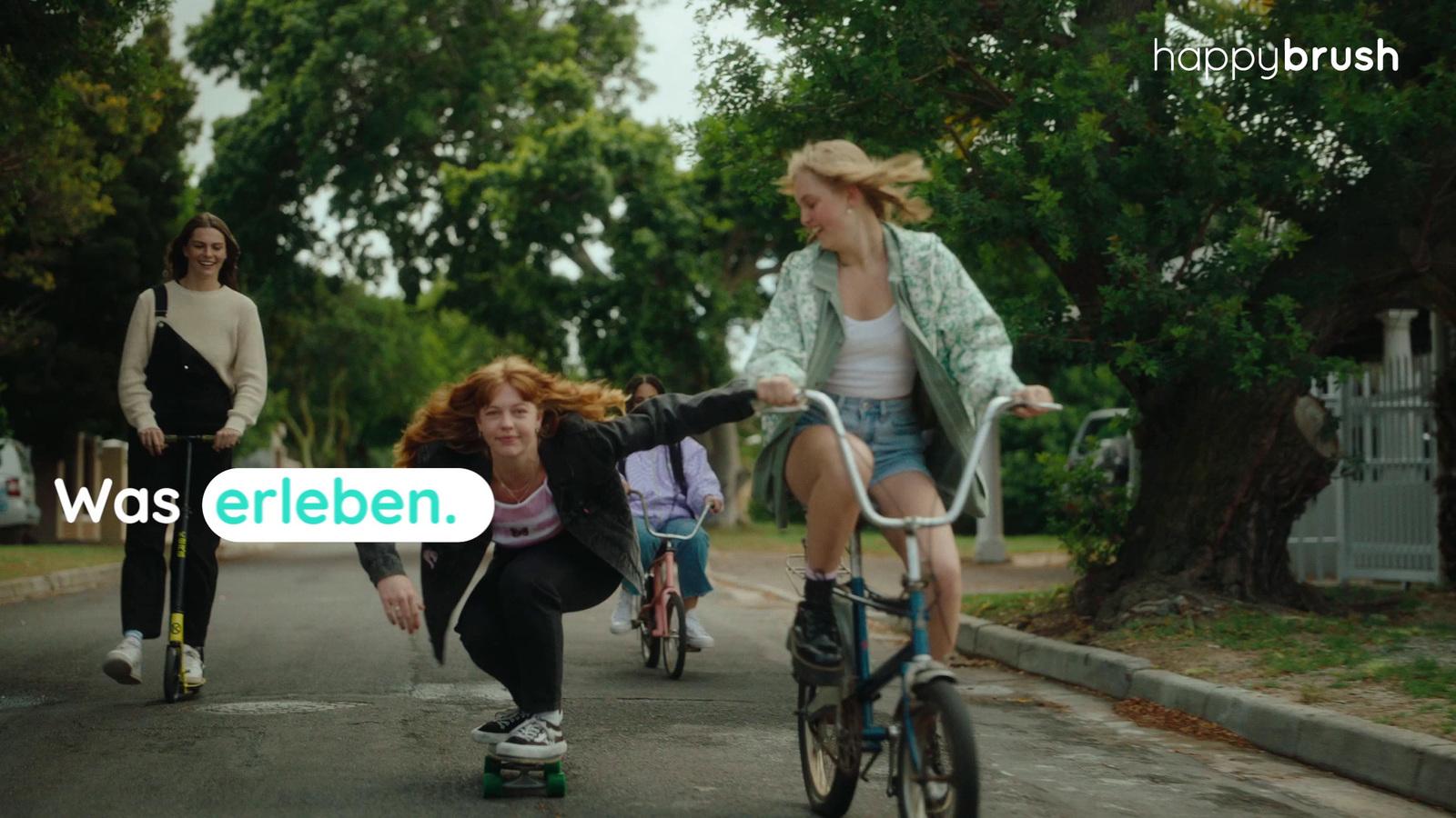 a group of women riding bikes down a street