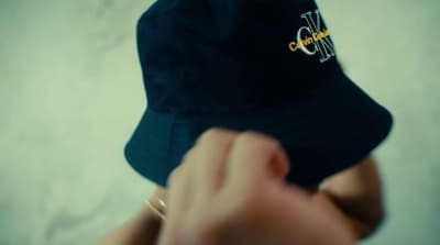 a person wearing a black hat with a yellow logo on it
