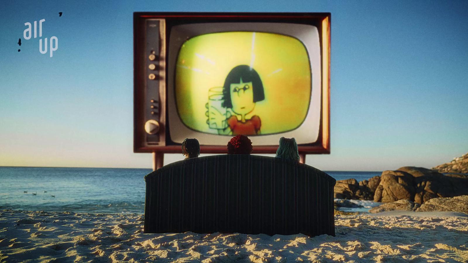 a person sitting in front of a tv on a beach