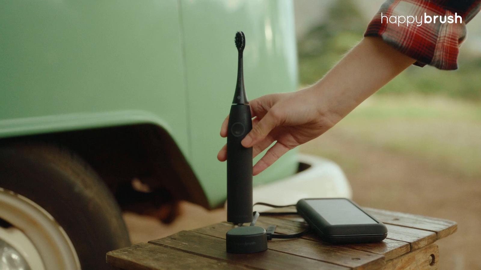 a person holding a cell phone near a green truck