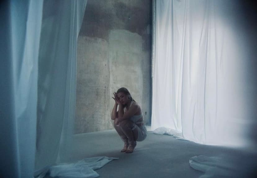 a woman kneeling down in front of a curtain