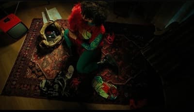 a woman sitting on top of a rug on top of a wooden floor
