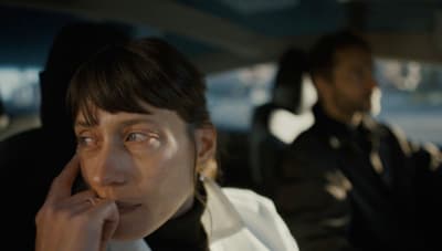 a woman sitting in a car talking on a cell phone
