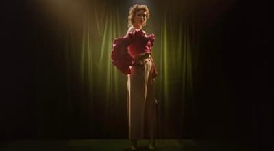 a woman standing in front of a spotlight on a stage