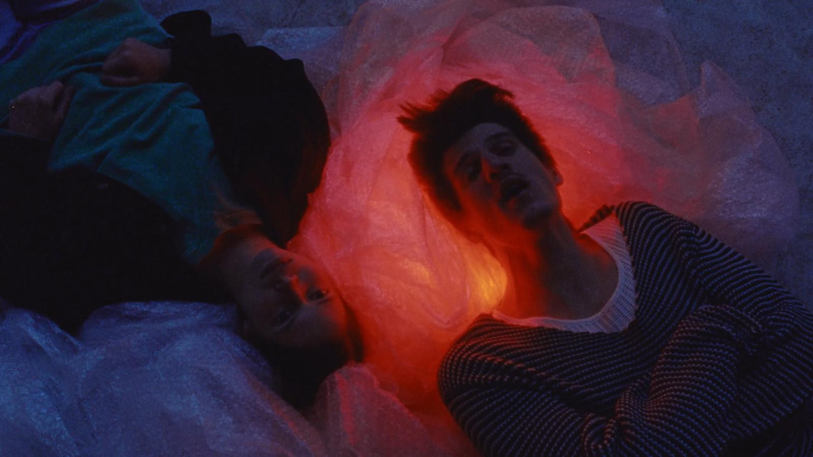 a couple of people laying on top of a bed