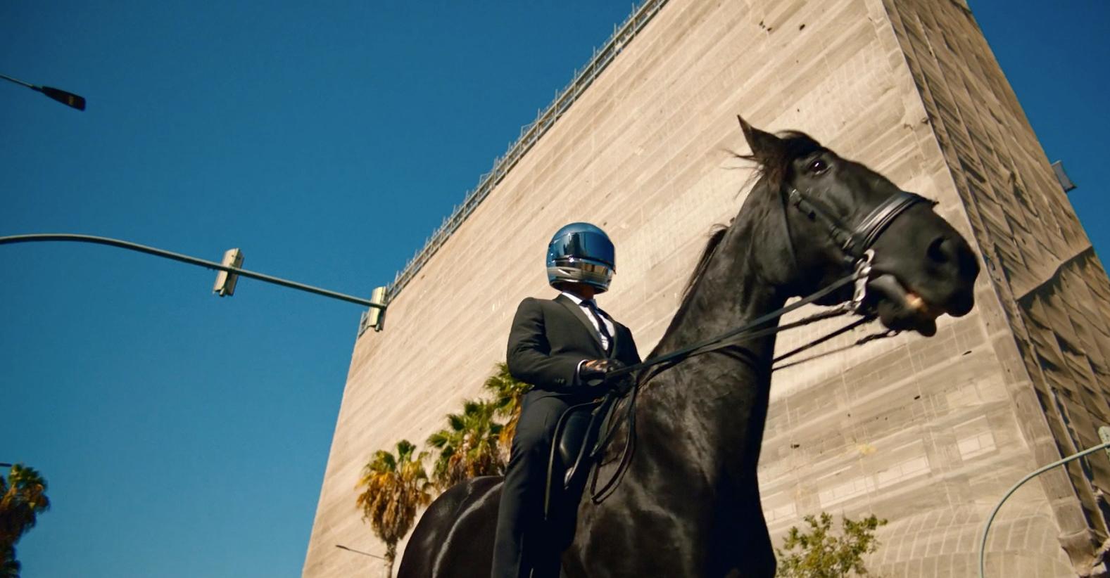 a man in a suit and helmet riding a horse