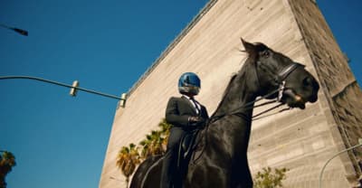 a man in a suit and helmet riding a horse