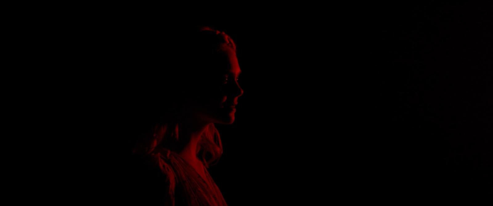 a woman standing in the dark in the dark