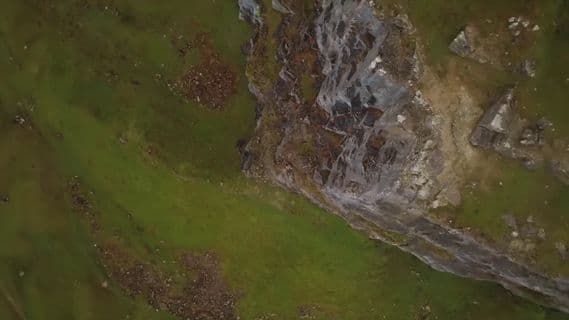 an aerial view of a grassy area with rocks and grass
