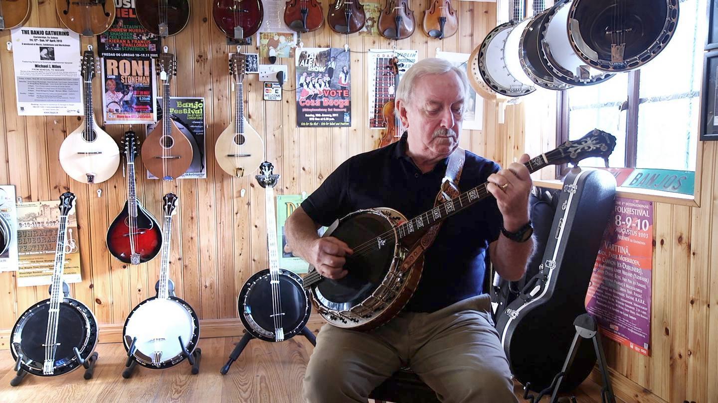 a man sitting on a chair playing a guitar