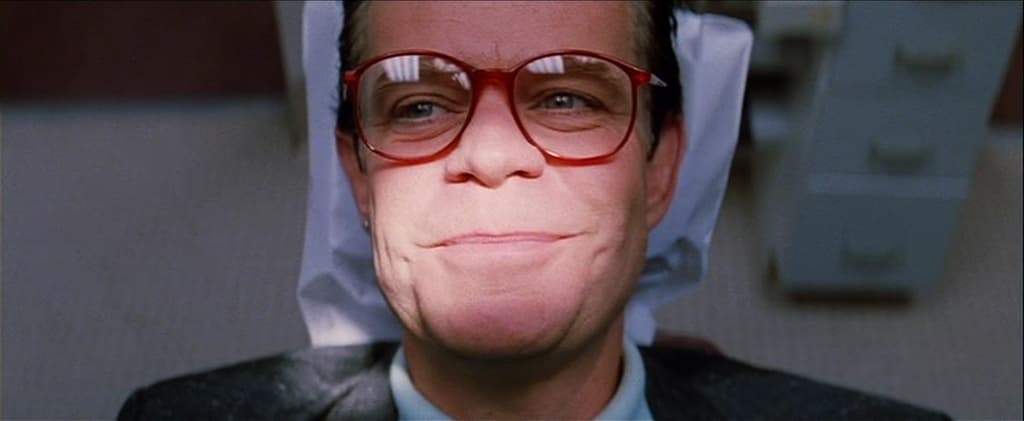 a man in a suit and tie wearing glasses