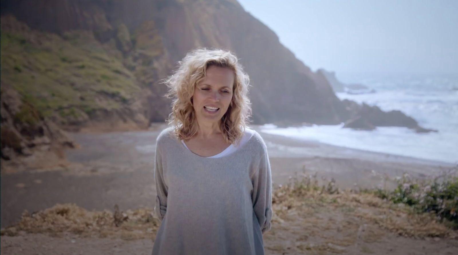 a woman standing on a beach next to the ocean