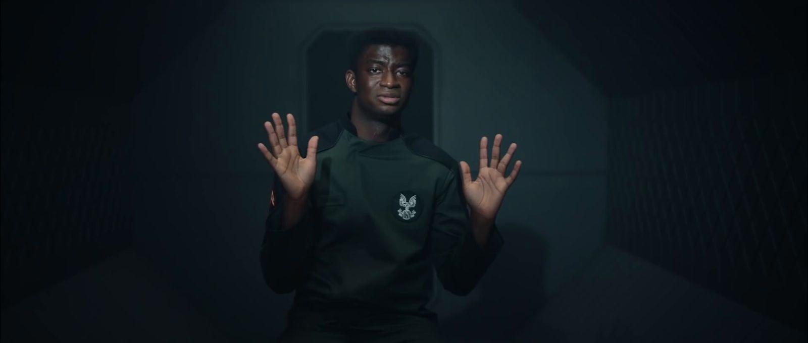 a man standing in a dark room holding his hands up