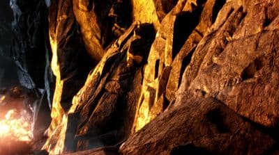 a man standing next to a fire in a cave