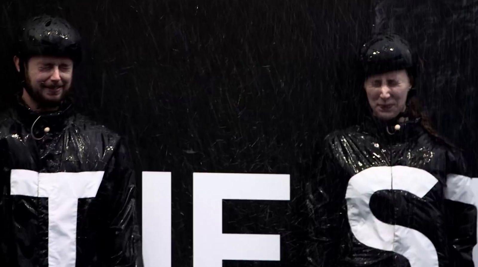 a couple of people that are standing in the rain
