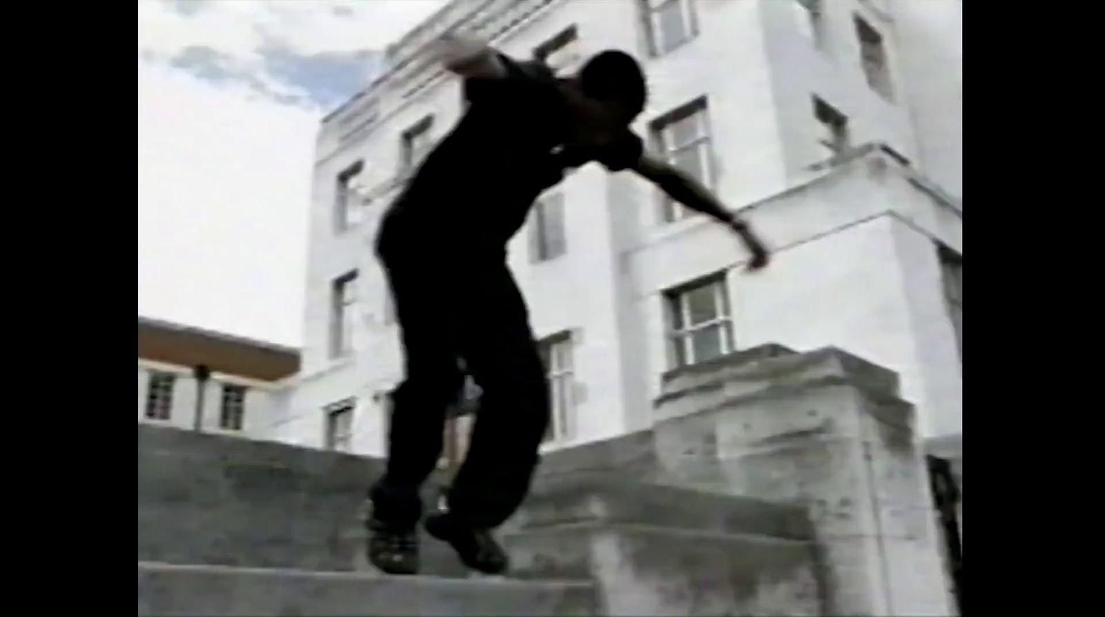 a man riding a skateboard down the side of a cement wall