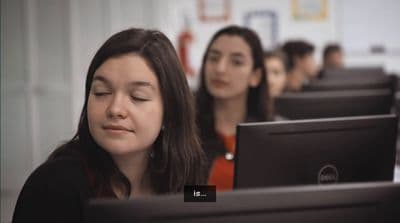 a group of women sitting in front of computers