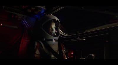 a man in a space suit in a dark room