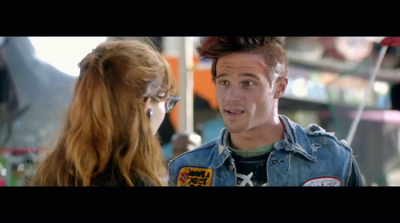 a man in a jean jacket talking to a woman