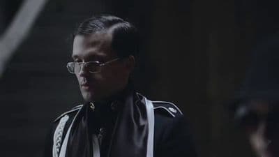 a man wearing glasses and a leather jacket